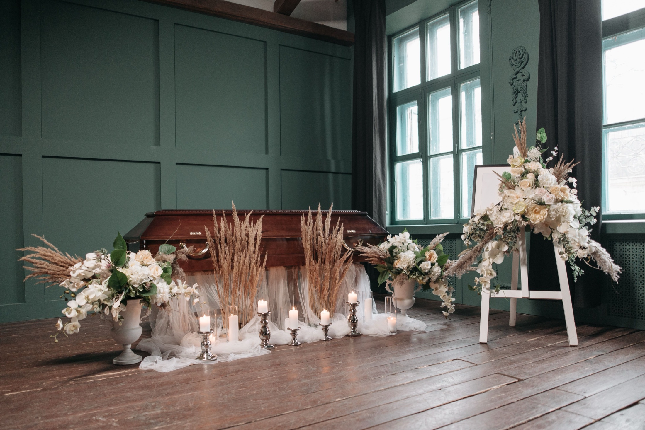 A funeral home chapel arranged with white flowers and candles